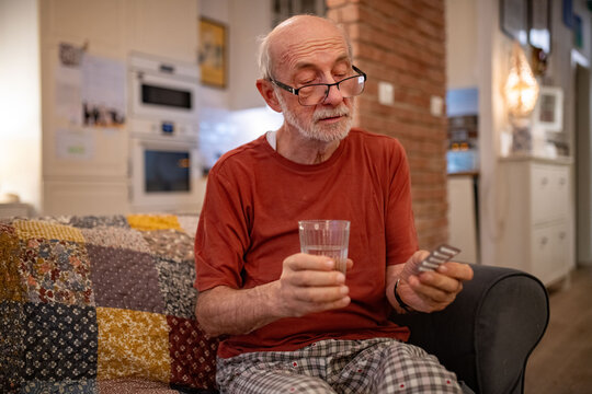 Senior man taking prescribed pills before going to sleep.