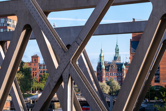 Urban landmark architecture seen through steel framework on bridge in Speicherstadt Hamburg Germany captured in crisp daylight skyline