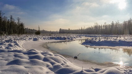 A snowy landscape with a river running through it.