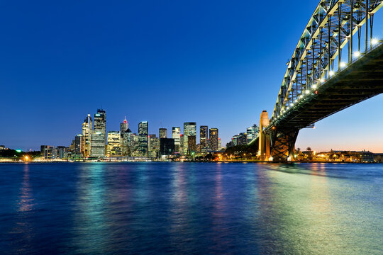 Sydney Harbour Bridge and city skyline at dusk.