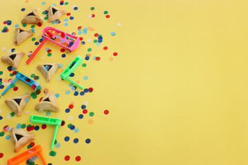 Purim celebration concept (jewish carnival holiday) over yellow background