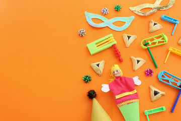 Purim celebration concept (jewish carnival holiday) over orange background