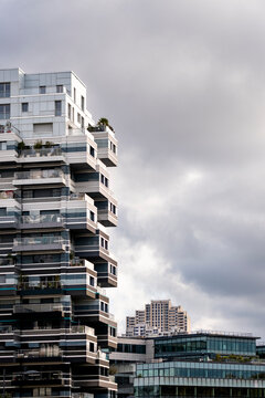 Modern residential architecture in Paris France featuring a tower with balcony facade pattern in an urban skyline scene under cloudy weather