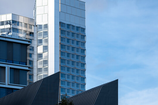 Modern tower skyscraper architecture in Paris France with glass facade rising into blue sky creating a clean skyline view with sharp lines and reflections