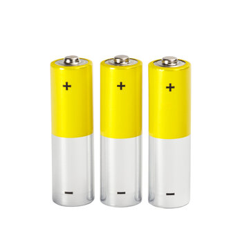 Three yellow-silver AA alkaline batteries with plus and minus signs stand vertically next to each other on transparent  white background. Electric energy concept.