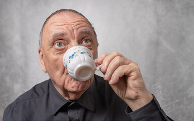 portrait gros plan homme qui bois un caf&eacute; sur fond gris