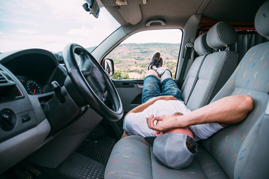 Young man with leg prosthesis resting in camper van