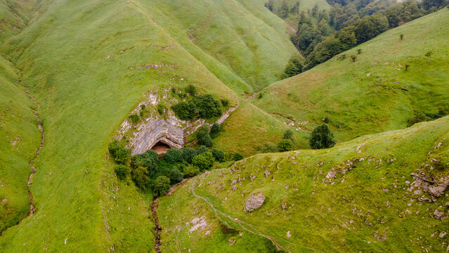 Arpea Cave nestled in lush green hills near France