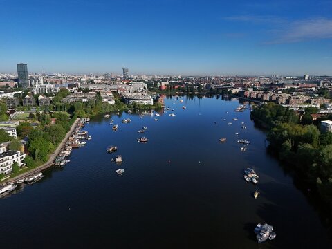 Aerial view of boats dotting the tranquil waters of the Rummelsburger Bucht, reflecting the clear sky, amidst the cityscape, Berlin, Berlin, Germany.