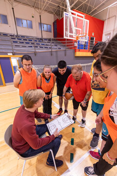 Inclusive Basketball Team Listening to Coach During Training