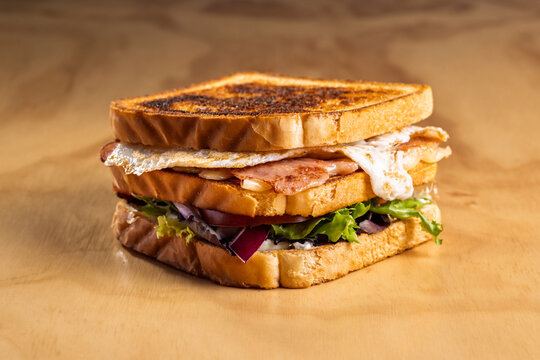 Ham and cheddar sandwich with fried egg and veggies