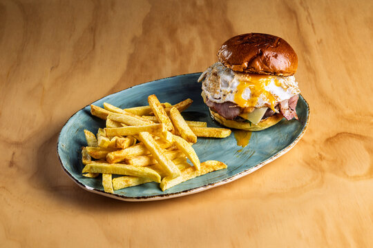 Aged beef burger with bacon, cheese, egg, and fries