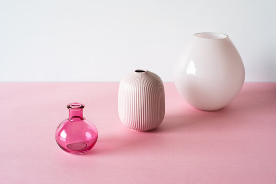 Three elegant vases on a soft pink background