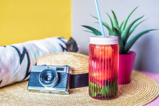 Summer essentials with camera, straw hat, and drink