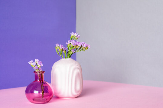 Minimalist flowers in pink and white vases on pastel backdrop