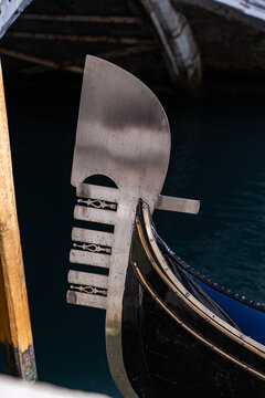 Gondola prow detail against Venetian canal and bridge