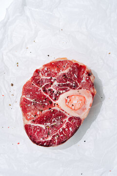 Raw veal shank garnished with coarse seasoning