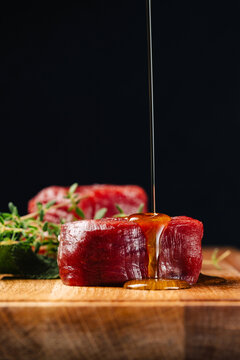 Raw beef tenderloin with marinade drizzling over filet mignon