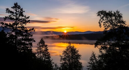 Obraz premium serene sunrise over a misty mountain lake, featuring a prominent sunburst, calm water reflections
