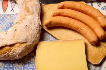 Ingredients for Aligot: Alsatian sausages, French Tome cheese, and ring-shaped bread.