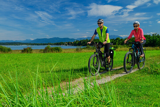 Cyclists riding bikes on a path by Starnberger See in Bavaria, Germany
