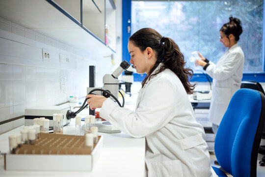 Scientist working with microscope in laboratory conducting research