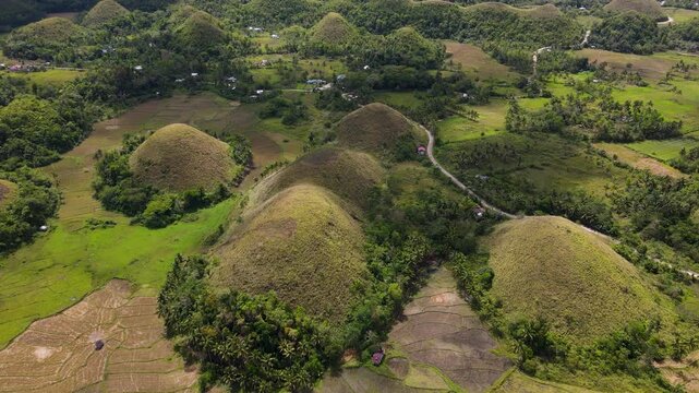 Aerial view of the iconic Chocolate Hills, with their unique rounded shapes contrasting against the lush green landscape, Bohol, Central Visayas, Philippines.