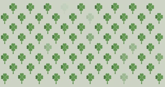 Digital animation of multiple clover leaves flickering against grey background