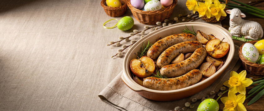 Pieczona biała kiełbasa serwowana z pieczonymi jabłkami w aranżacji wielkanocnej