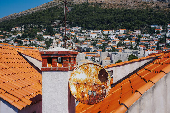 View of sun-drenched terracotta rooftops cascading towards the shimmering Adriatic, with ancient walls and distant mountains blending history and nature, Dubrovnik, Dubrovnik-Neretva County, Croatia.