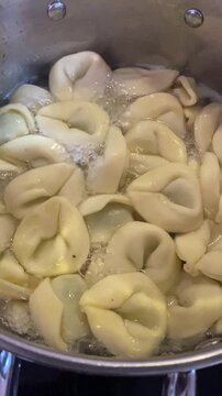 Frische Teigtaschen garen im kochenden Wasser. Ideal f&uuml;r Themen K&uuml;che, Rezept, Tradition und internationale Gerichte.
