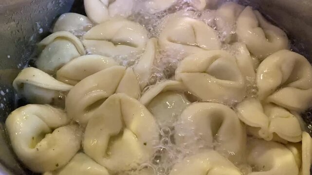 Frische Teigtaschen garen im kochenden Wasser. Ideal f&uuml;r Themen K&uuml;che, Rezept, Tradition und internationale Gerichte.