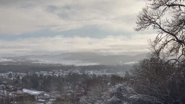 A view of a winter village. Grantown-on-Spey from above. Winter mountains and a snow-covered village in Scotland.