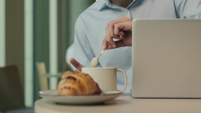 Ethnic Indian business man concentration working project analyze typing laptop stirring sugar in cup of coffee tea Arabian businessman with modern network website chatting drinking male guy in cafe