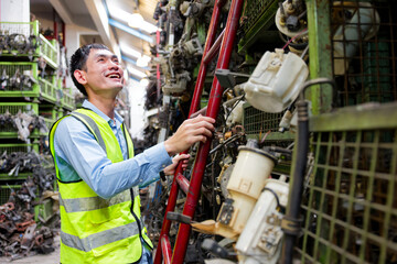 Worker examining parts on a shelf in a storage facility