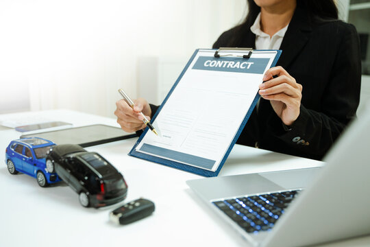 Car accident models with insurance contract and pen. Auto claim, coverage, liability, compensation and settlement process in modern business office.