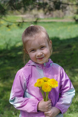 Girl 5 years picking flowers in spring meadow
