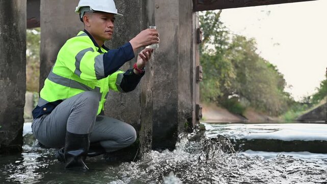 Engineer collected water sample in Erlenmeyer glass bottle to check water quality at the water gate