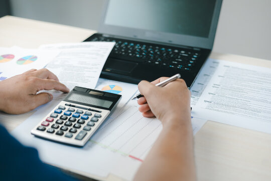 Business professional calculating tax return with financial documents, laptop and calculator. Concept of GST, income tax filing, accounting analysis, corporate finance and tax compliance.