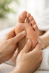 Close-up of hands performing a foot massage on a relaxed foot