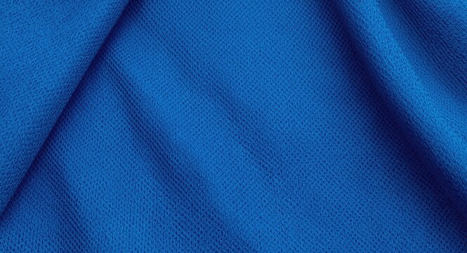 Overhead close up of the textured surface of a blue sports jersey fabric