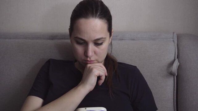 Woman staying connected by scrolling on her smartphone at home.