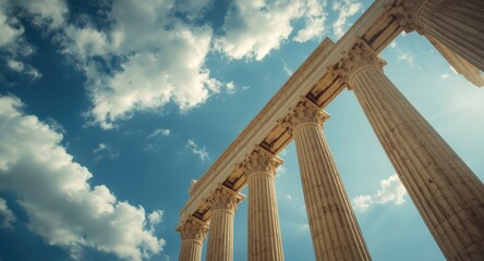 Fototapeta premium Tall ancient Greek columns reaching to a bright blue sky with scattered white clouds and designated copy space