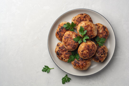 Fried meat cutlets in plate on concrete background