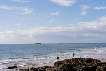 People on rocky outcrop above Atlantic waves in Cascais