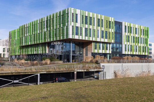 Modern L'Oreal corporate office building in Hoofddorp, Netherlands, with distinctive green vertical fins and sustainable architectural design.