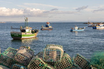 Fishing boats offshore from Cascais marina with traps foreground