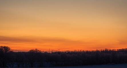 Naklejka premium Winter twilight sky glowing with rich golden shades and calm