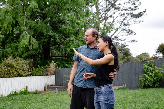 Mixed ethnicity standing on a grassy backyard