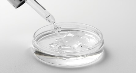 Precision dropper delivering translucent gel with different bubble sizes into a petri dish as part of skin product research